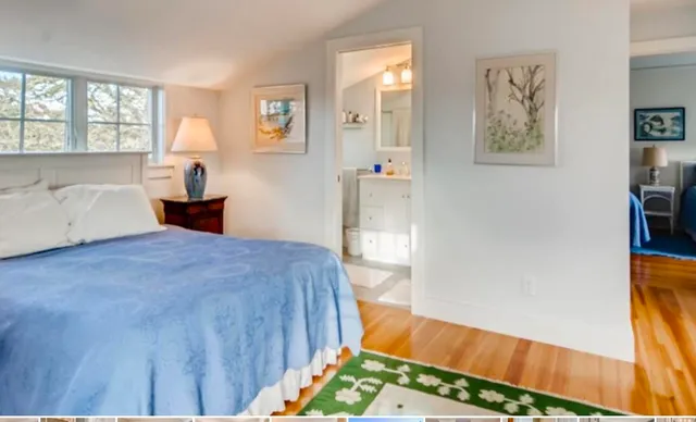 a bedroom with a bed and a view of living room