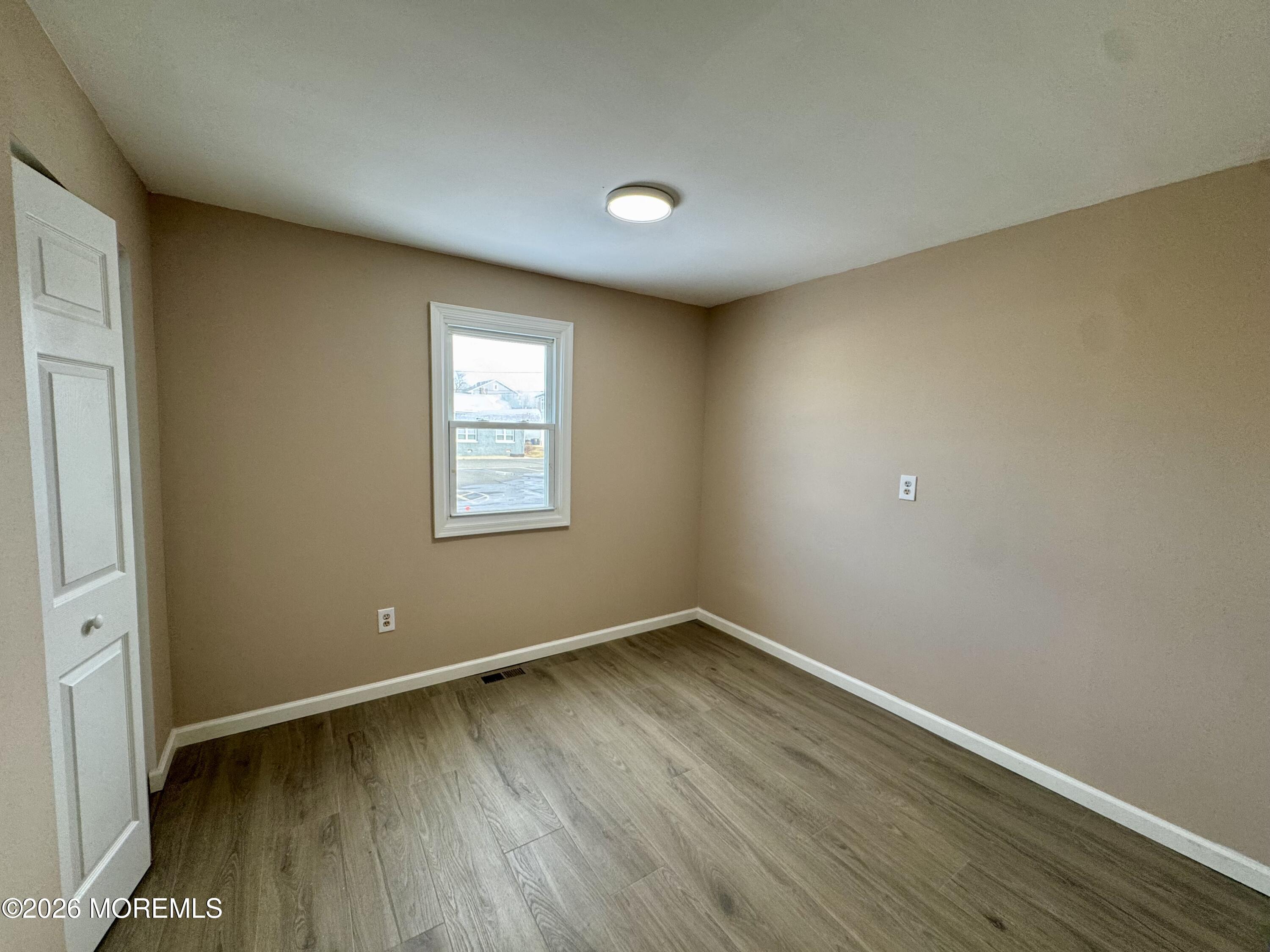 20 Bray Avenue Middletown, NJ 07748 - Photo 6 of 10 an empty room with wooden floor and windows