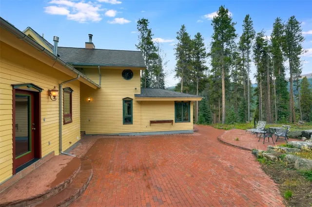 a view of a house with backyard and trees