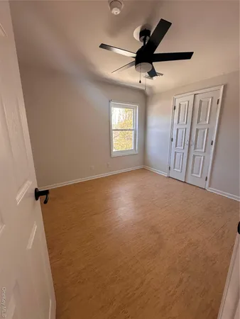 an empty room with windows and fan