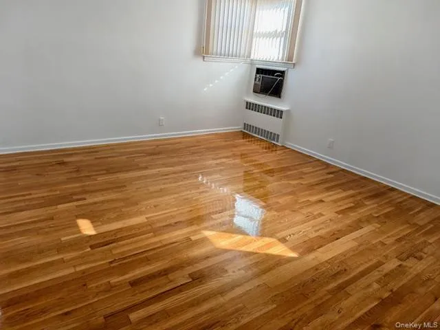 a view of a room with wooden floor and white walls