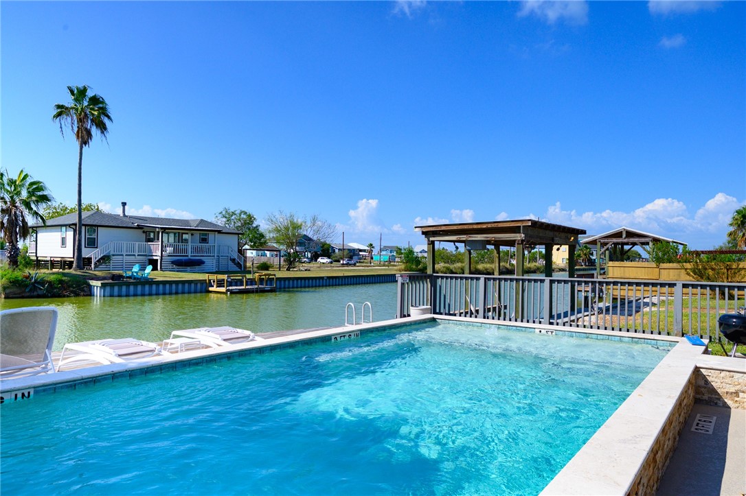 102 Ball Street Rockport, TX 78382 - Photo 15 of 40 a view of a swimming pool with a table under an umbrella