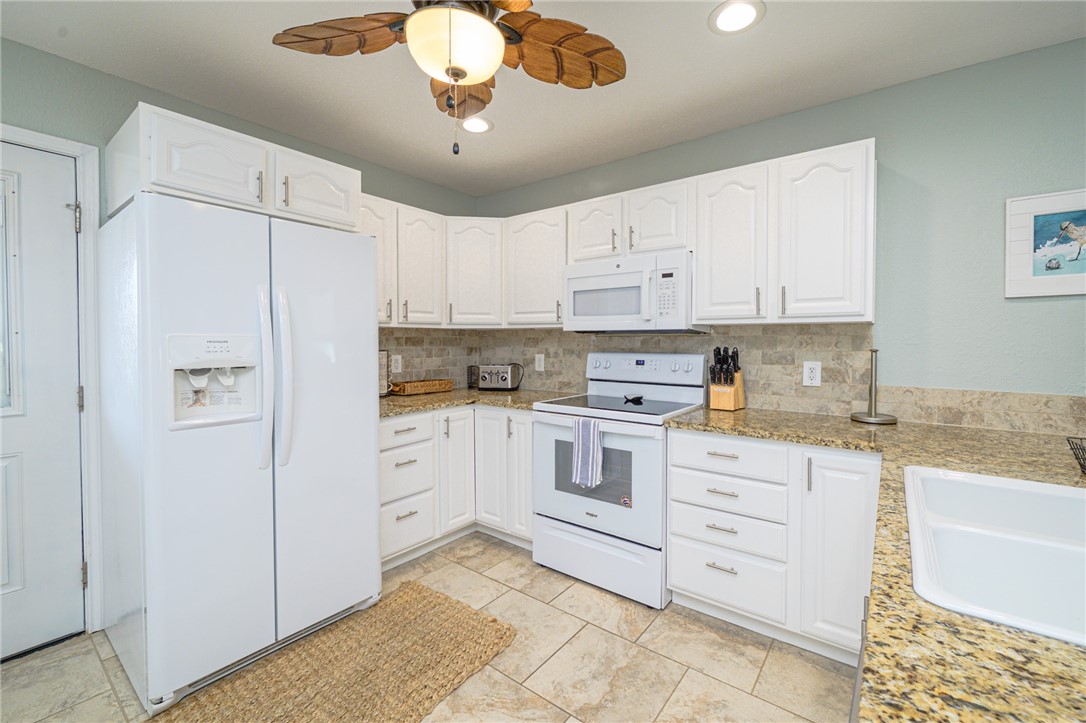 102 Ball Street Rockport, TX 78382 - Photo 25 of 40 a kitchen with cabinets stainless steel appliances and a counter space