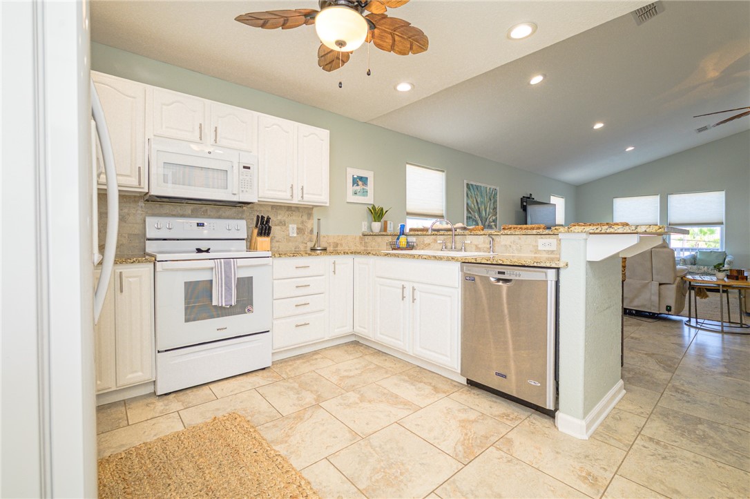 102 Ball Street Rockport, TX 78382 - Photo 26 of 40 a kitchen with a stove top oven sink and cabinets