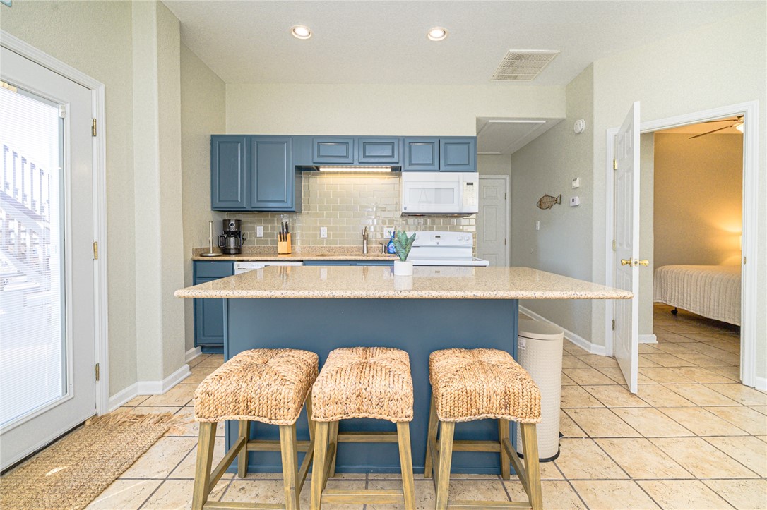 102 Ball Street Rockport, TX 78382 - Photo 35 of 40 a kitchen with a table chairs sink and cabinets