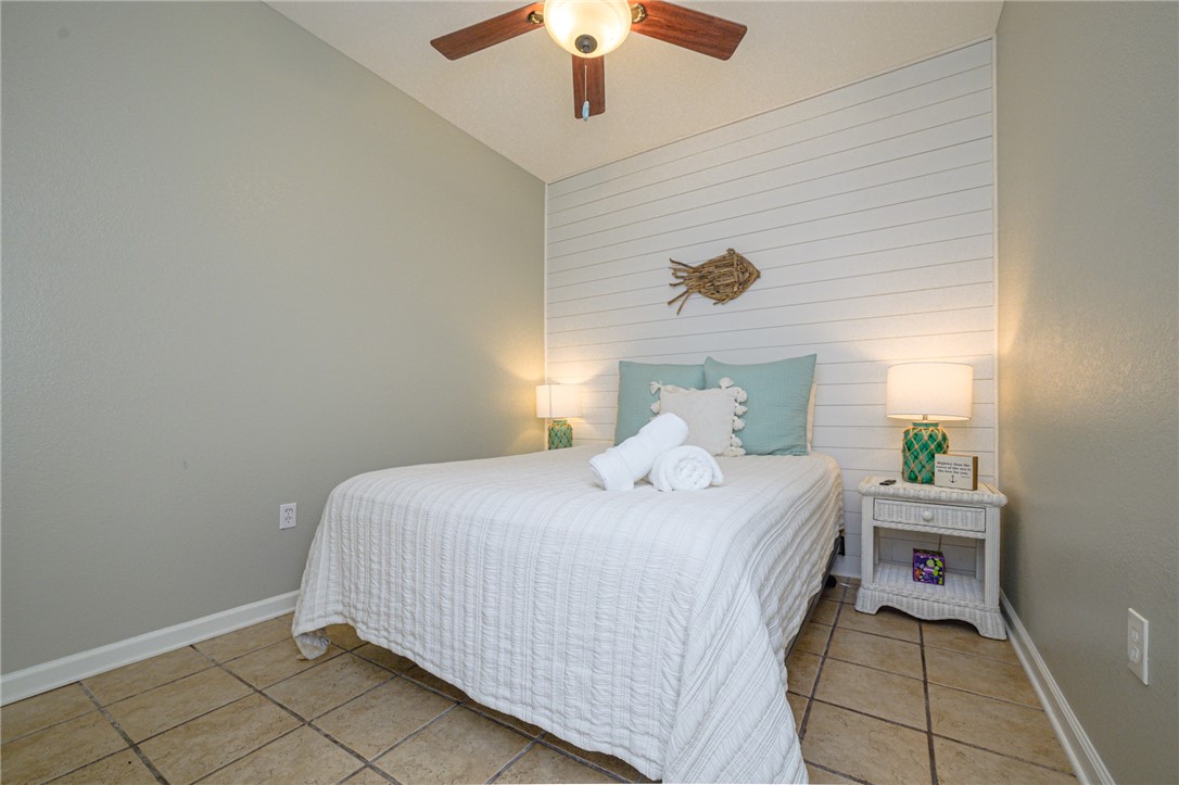 102 Ball Street Rockport, TX 78382 - Photo 37 of 40 a bedroom with a bed and a chandelier