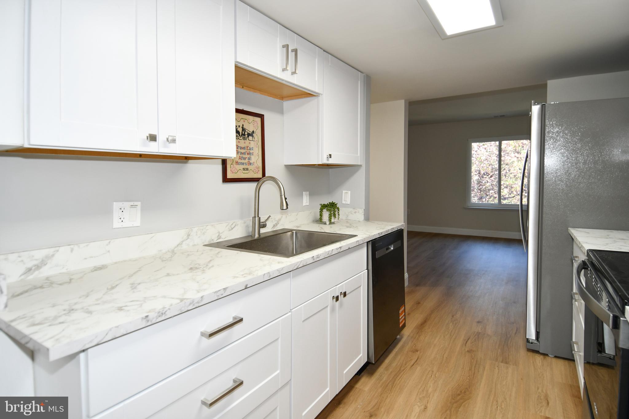 15003 Candover Court, Unit 281C Silver Spring, MD 20906 - Photo 12 of 42 a kitchen with sink cabinets and wooden floor