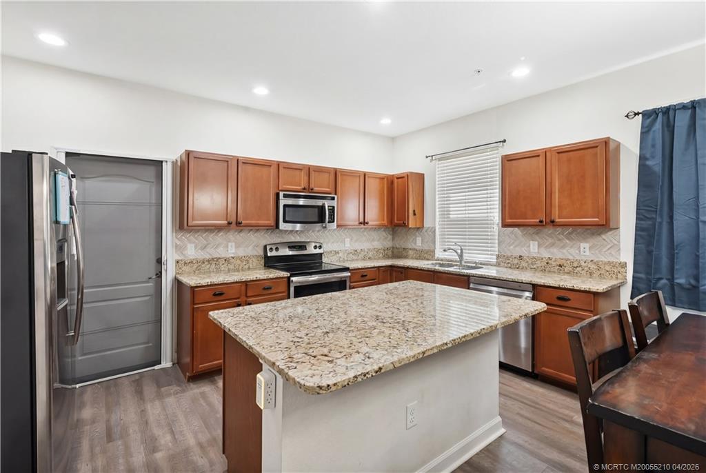 9456 Southwest Merlin Court Stuart, FL 34997 - Photo 11 of 23 a kitchen with stainless steel appliances granite countertop a sink stove microwave and refrigerator