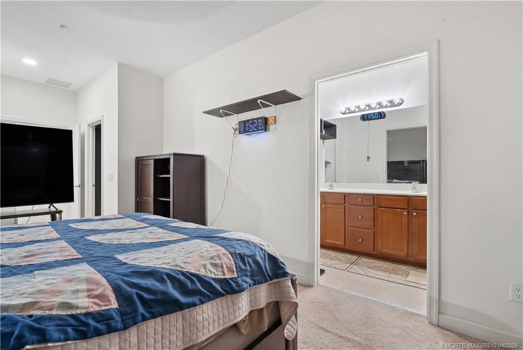 9456 Southwest Merlin Court Stuart, FL 34997 - Photo 15 of 23 a bedroom with a bed and a flat screen tv