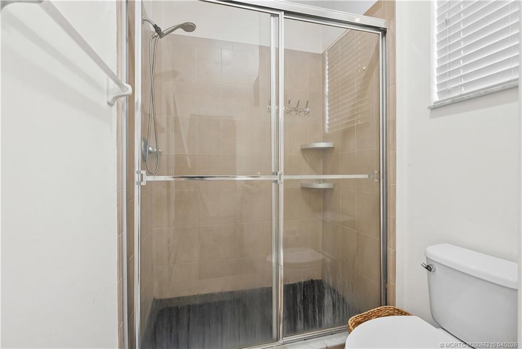 9456 Southwest Merlin Court Stuart, FL 34997 - Photo 17 of 23 a bathroom with a shower and toilet