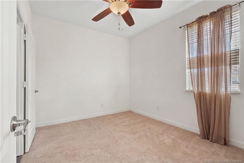 9456 Southwest Merlin Court Stuart, FL 34997 - Photo 20 of 23 an empty room with a window and a ceiling fan