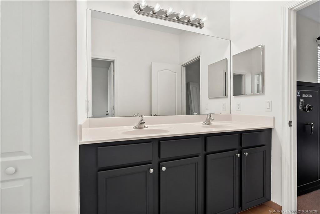 9456 Southwest Merlin Court Stuart, FL 34997 - Photo 21 of 23 a bathroom with double sink and mirror