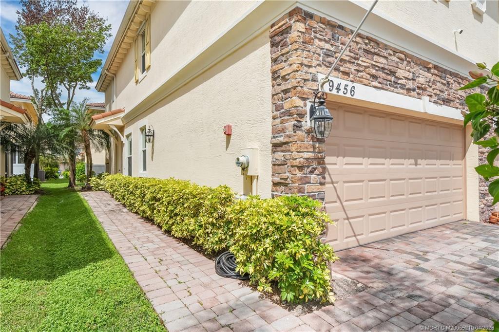 9456 Southwest Merlin Court Stuart, FL 34997 - Photo 4 of 23 a front view of a house with a garden