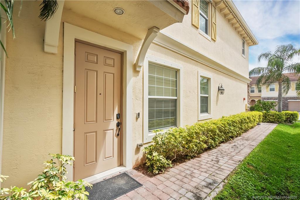 9456 Southwest Merlin Court Stuart, FL 34997 - Photo 5 of 23 a front view of a house with a yard