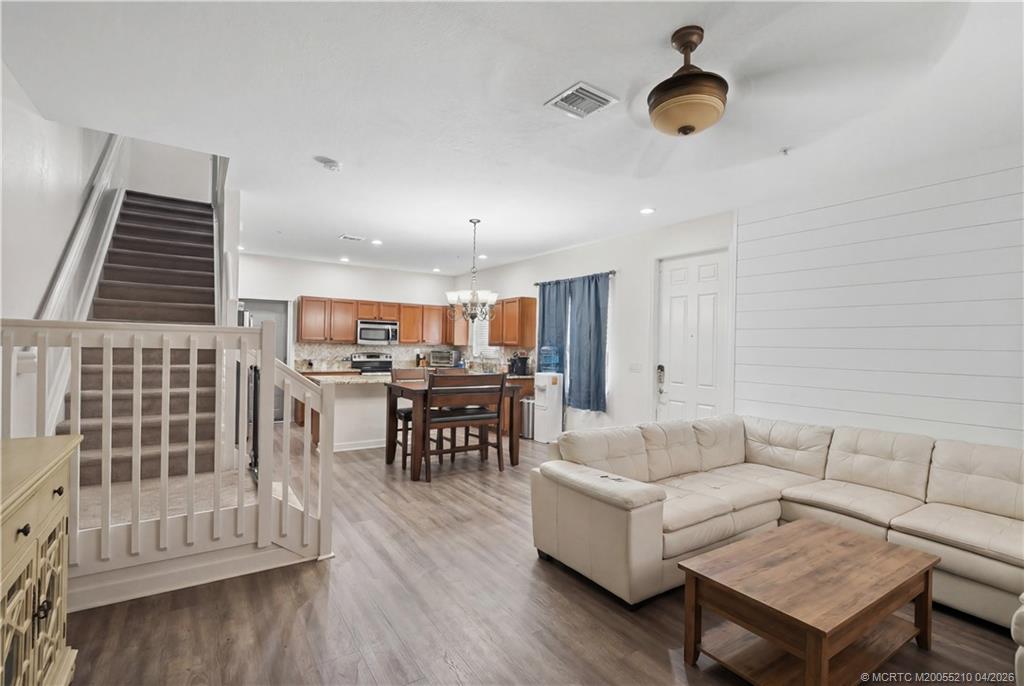 9456 Southwest Merlin Court Stuart, FL 34997 - Photo 6 of 23 a living room with furniture and a wooden floor
