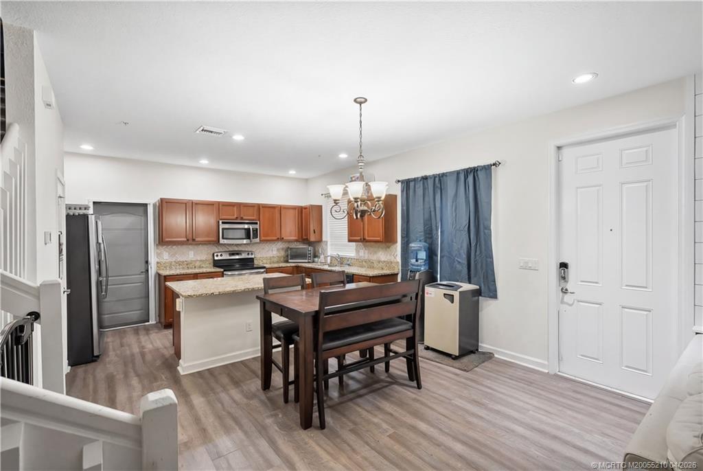 9456 Southwest Merlin Court Stuart, FL 34997 - Photo 7 of 23 a kitchen with a table and chairs in it