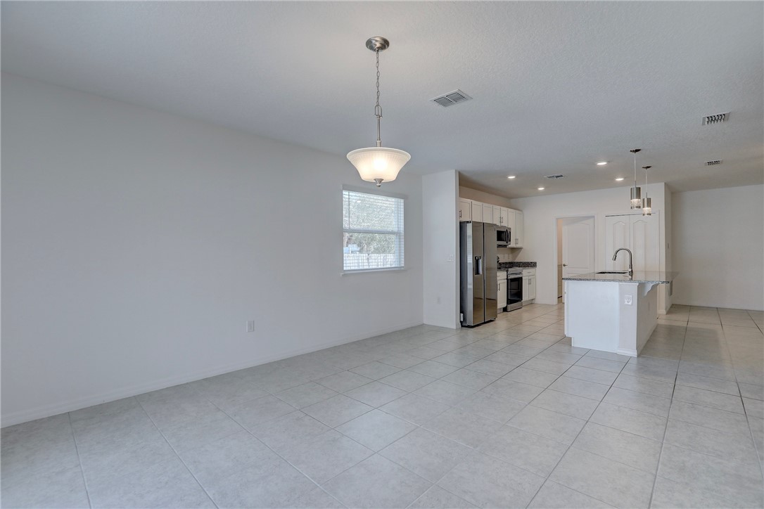 406 Easy Street Sebastian, FL 32958 - Photo 16 of 36 a view of a kitchen with a refrigerator a sink and dishwasher cabinets