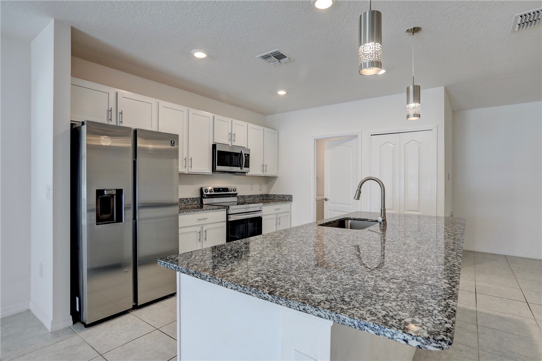 406 Easy Street Sebastian, FL 32958 - Photo 17 of 36 a kitchen with stainless steel appliances granite countertop a sink refrigerator and microwave