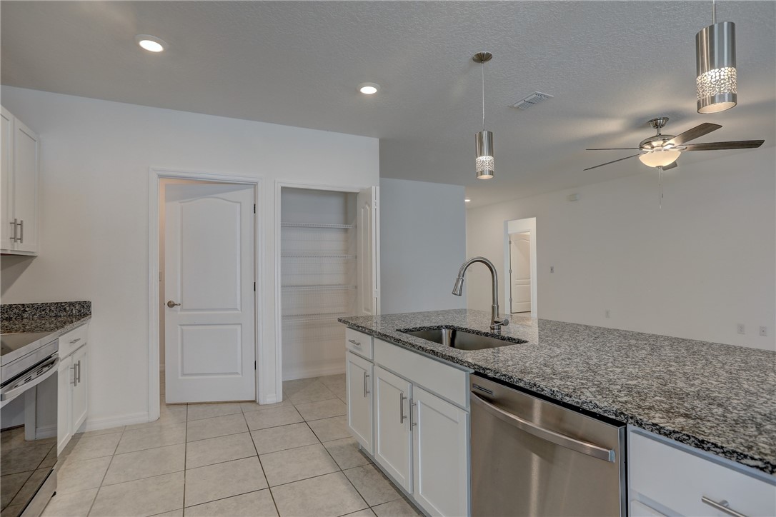 406 Easy Street Sebastian, FL 32958 - Photo 19 of 36 a kitchen with stainless steel appliances granite countertop a sink a stove a refrigerator and a counter top space