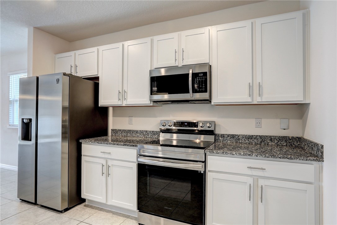 406 Easy Street Sebastian, FL 32958 - Photo 21 of 36 a kitchen with granite countertop white cabinets and stainless steel appliances