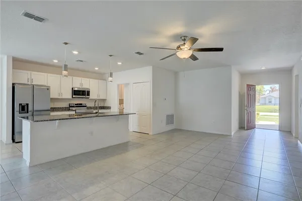 a view of a kitchen with a refrigerator a sink and dishwasher cabinets