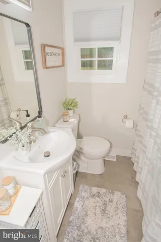 a bathroom with a sink toilet and a mirror