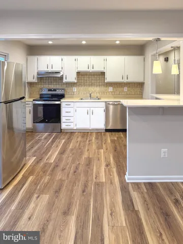 a large kitchen with granite countertop a stove a sink dishwasher and a refrigerator