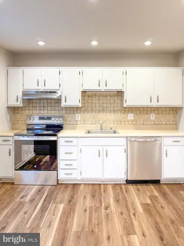 a kitchen with a stove a sink and a refrigerator