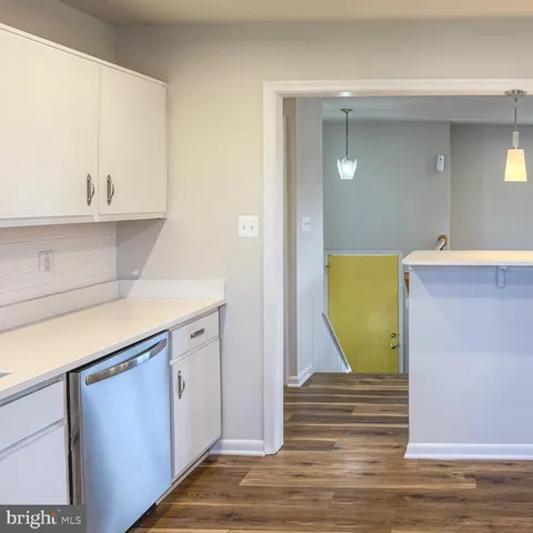 a kitchen with granite countertop white cabinets and white appliances