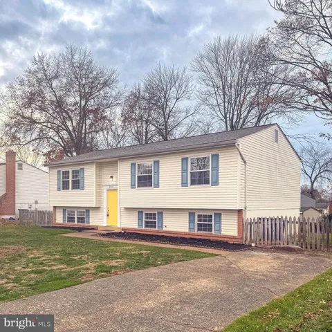 a view of a house with a big yard and large trees