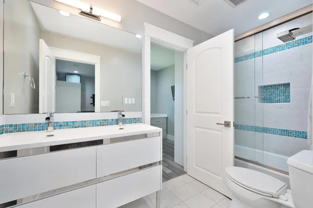 a bathroom with a sink a toilet and shower