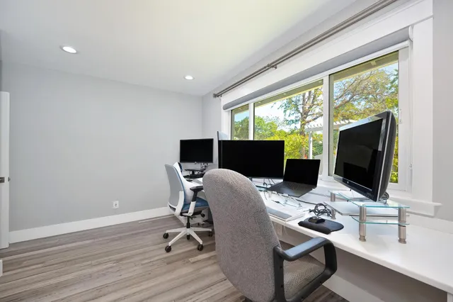 a view of a workspace with furniture and a window