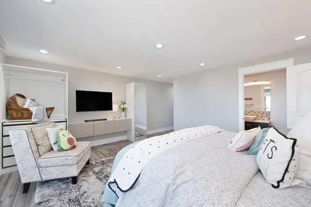 a spacious bedroom with a bed and a flat screen tv