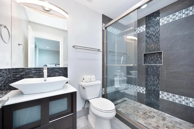 a bathroom with a sink a toilet and shower