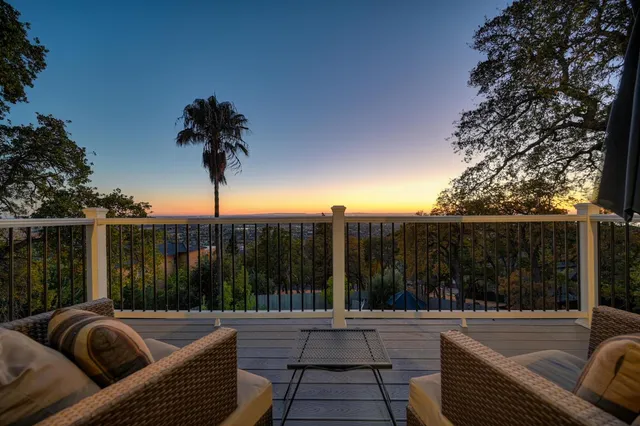 a view of roof deck with couches and wooden fence