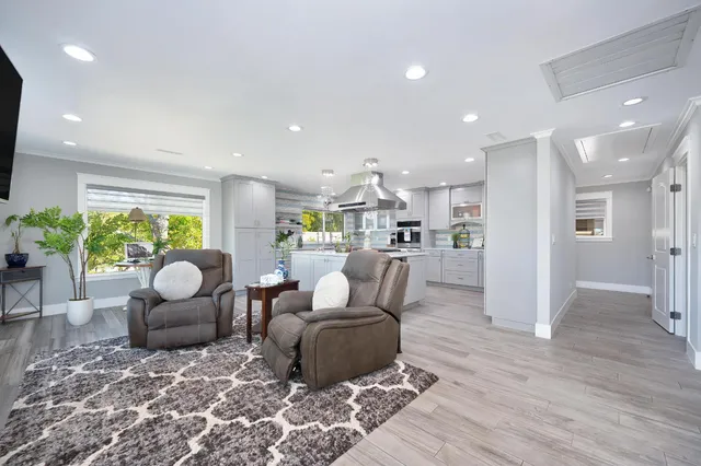 a living room with furniture and a view of kitchen