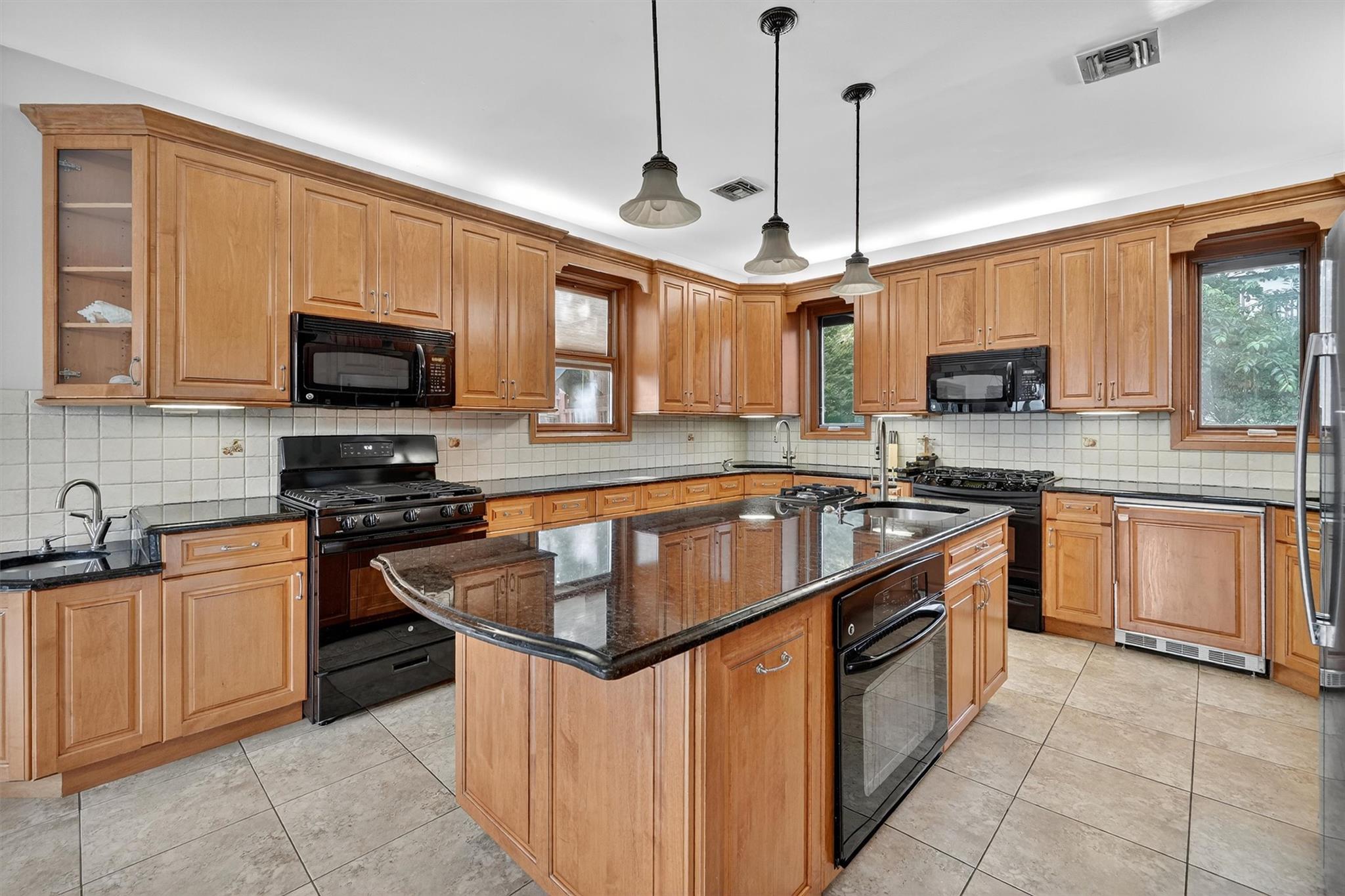 15 Dr Frank Road Spring Valley, NY 10977 - Photo 11 of 50 Kitchen with black appliances, plenty of natural light, and light tile patterned floors