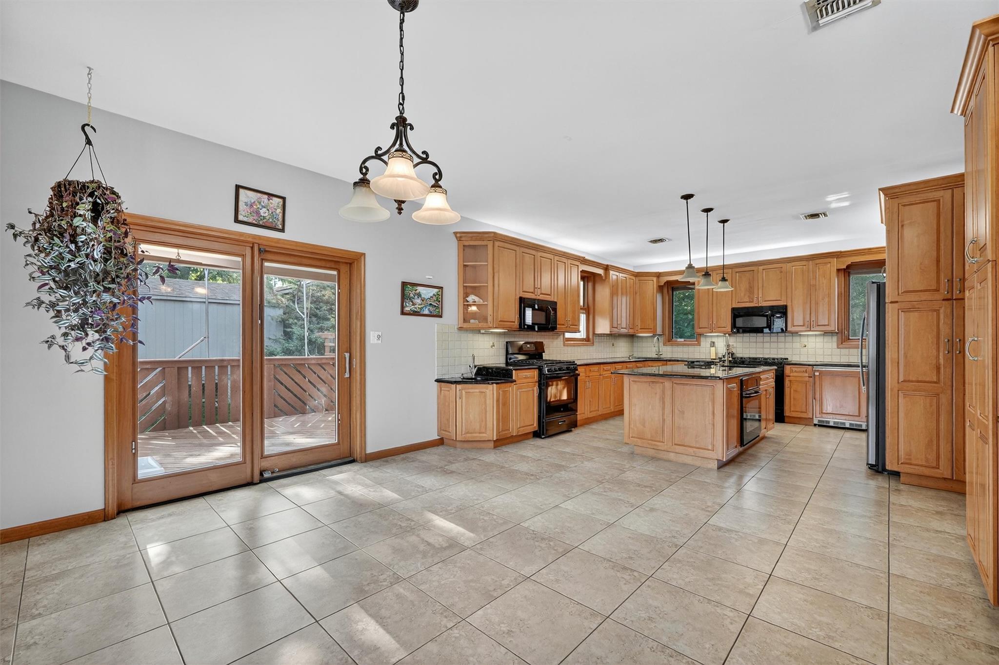 15 Dr Frank Road Spring Valley, NY 10977 - Photo 14 of 50 Kitchen with black appliances, decorative backsplash, open shelves, a kitchen island, and light tile patterned flooring