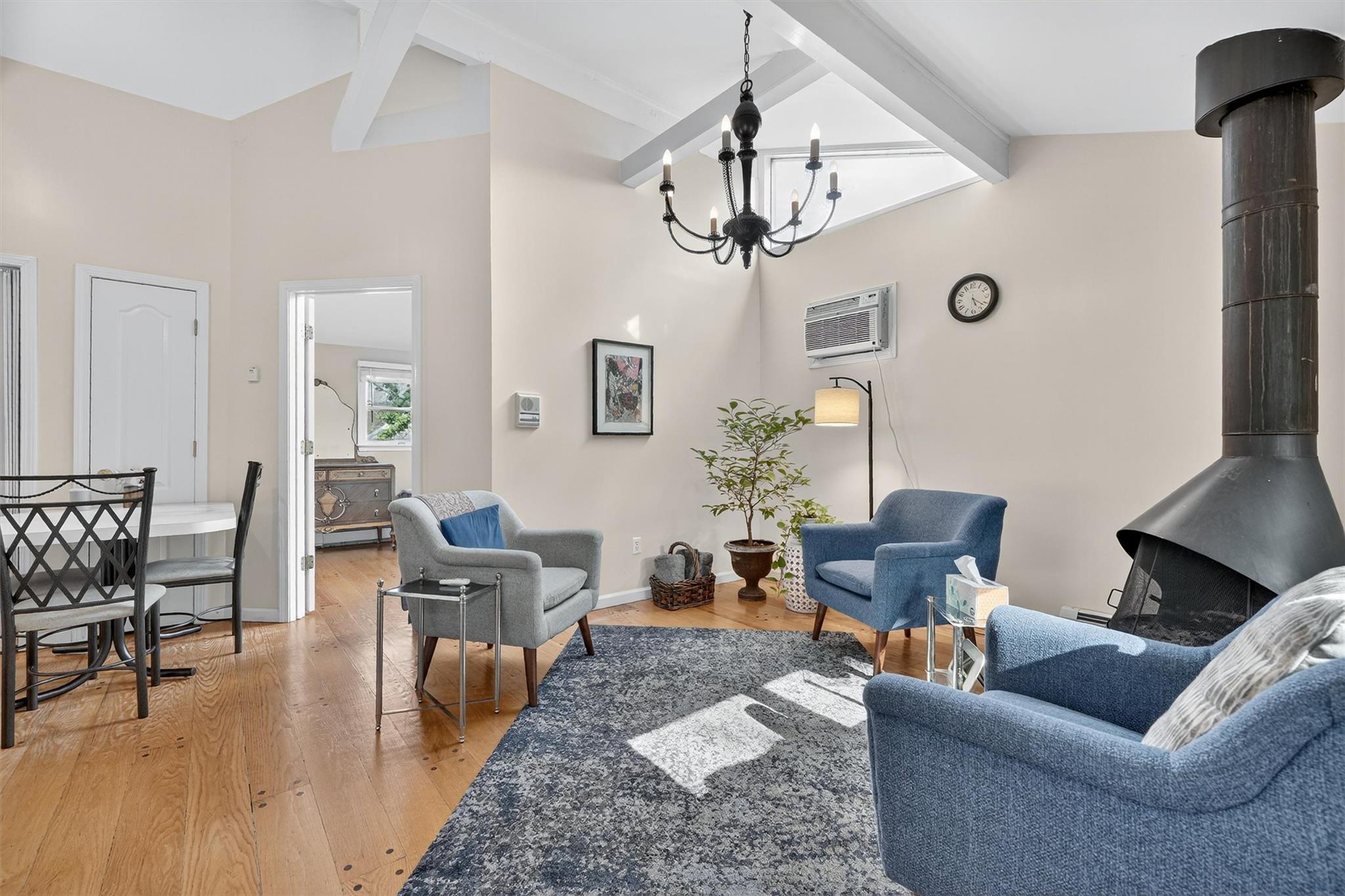 15 Dr Frank Road Spring Valley, NY 10977 - Photo 31 of 50 Living room featuring a wood stove, beam ceiling, a chandelier, light wood-type flooring, and high vaulted ceiling