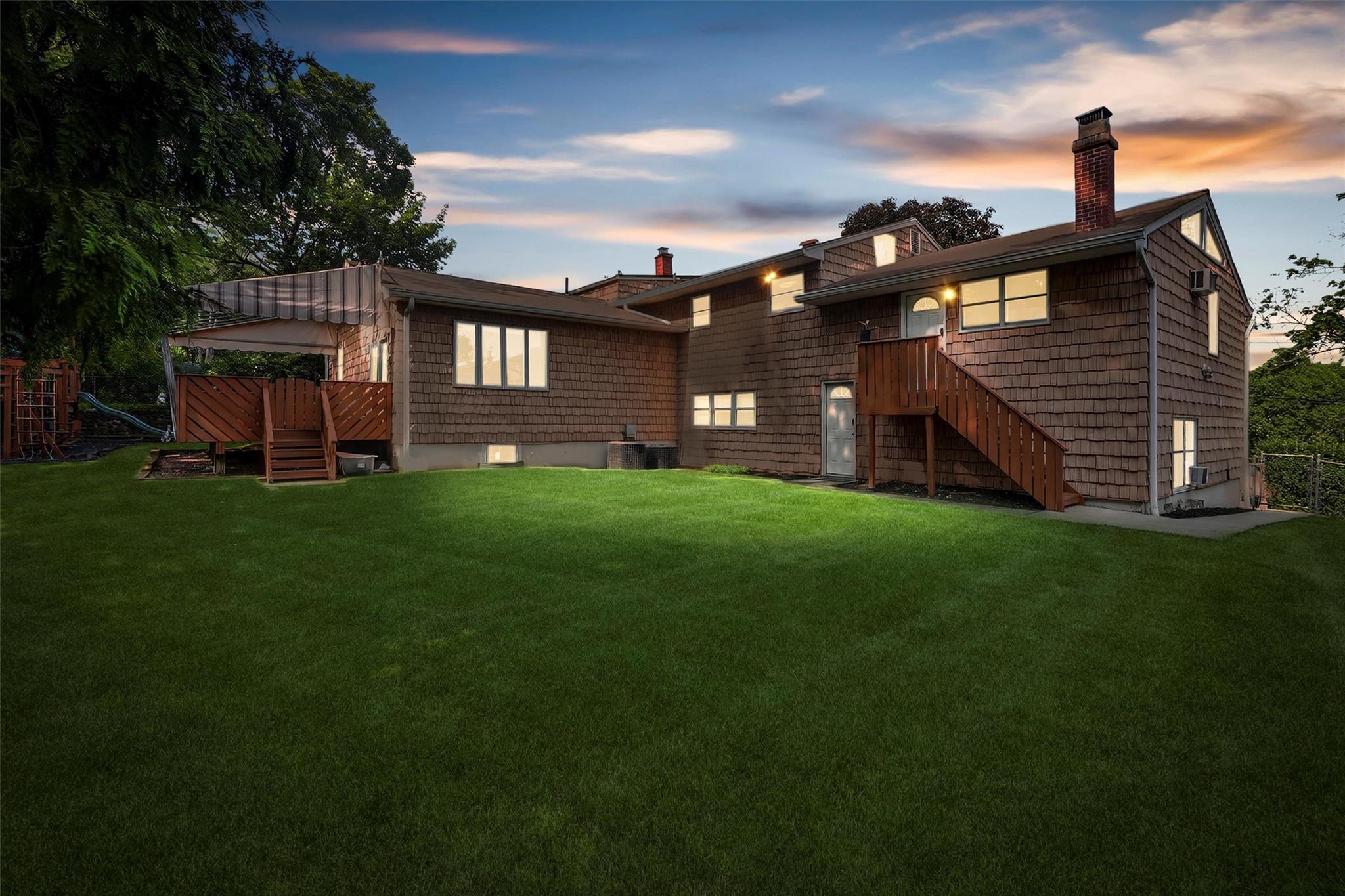 15 Dr Frank Road Spring Valley, NY 10977 - Photo 44 of 50 Back of house at dusk featuring stairs, a chimney, and a yard