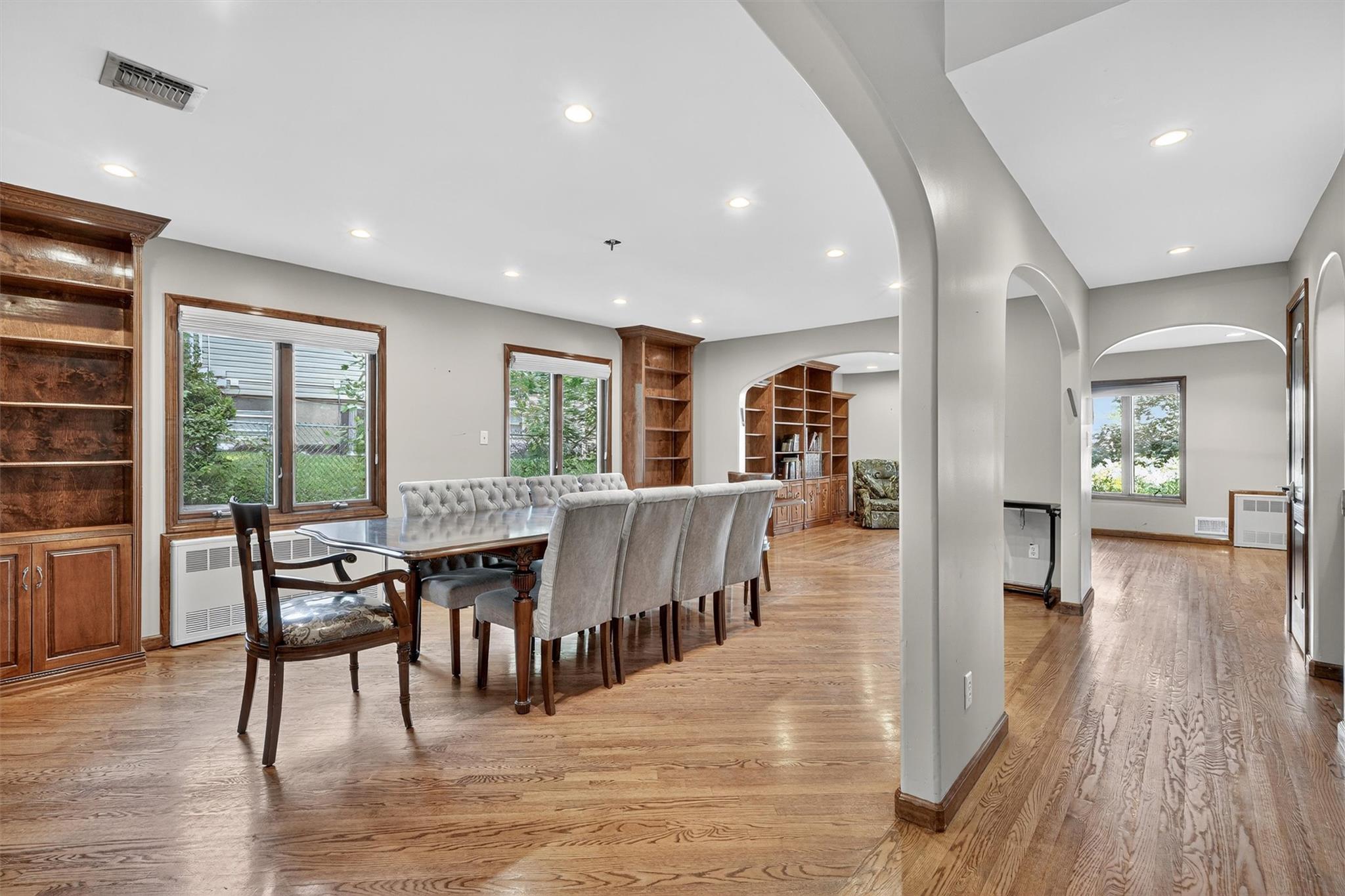 15 Dr Frank Road Spring Valley, NY 10977 - Photo 9 of 50 Dining area featuring radiator, arched walkways, built in shelves, light wood finished floors, and recessed lighting