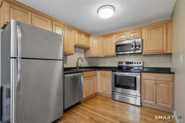 a kitchen with stainless steel appliances a refrigerator sink and microwave