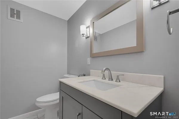 a bathroom with a sink toilet and a mirror