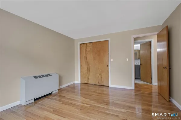 a view of room with an empty space and wooden floor
