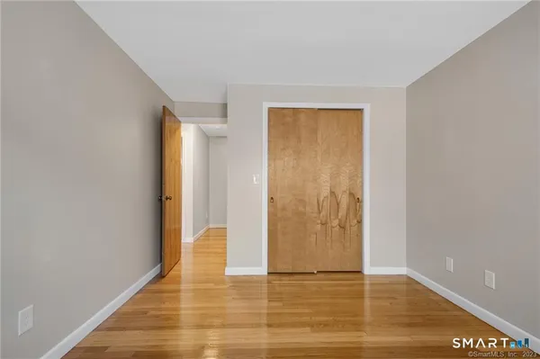 a view of an empty room with wooden floor