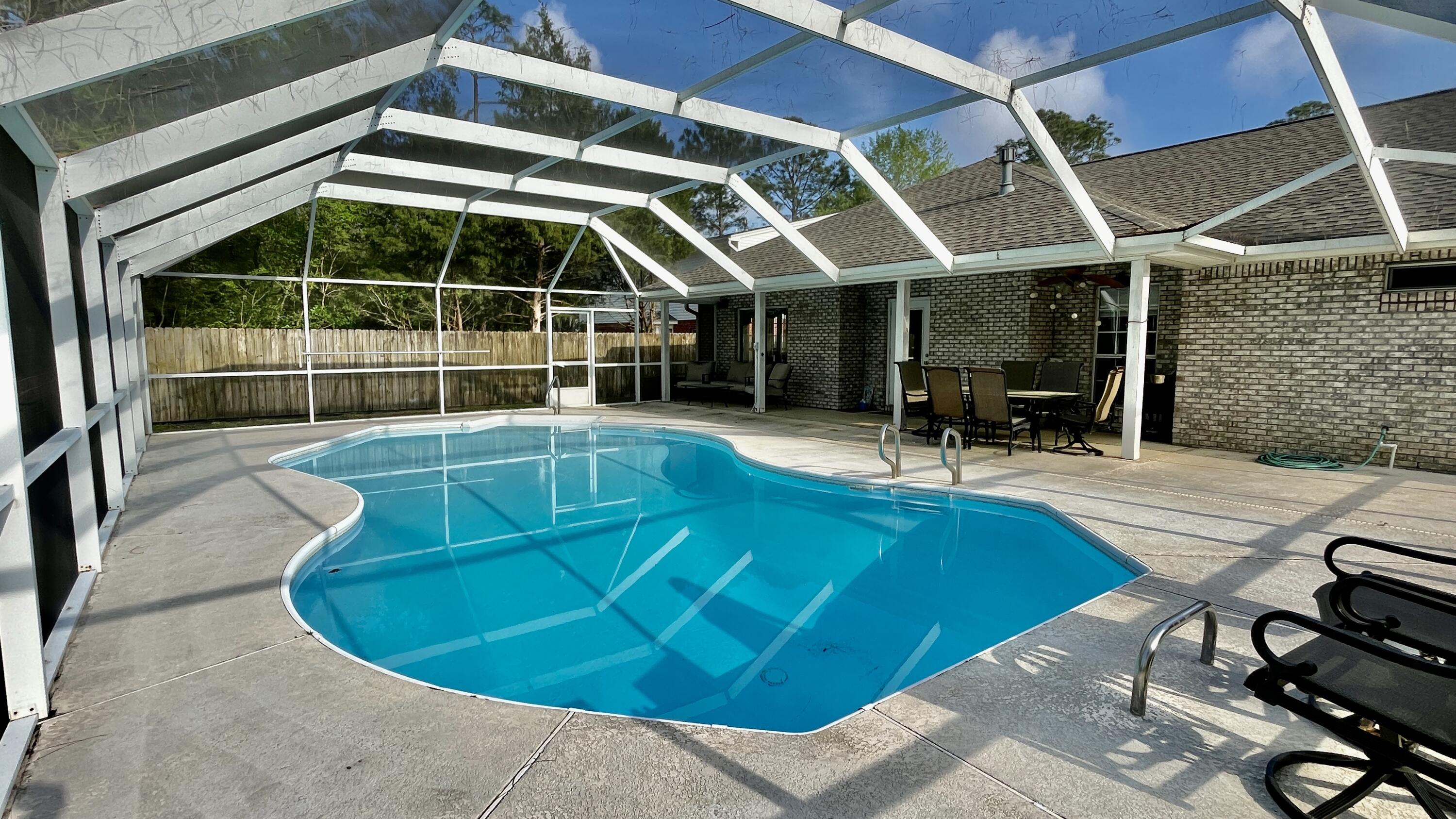 4467 Kingslynn Road Niceville, FL 32578 - Photo 23 of 28 a view of a swimming pool with chairs