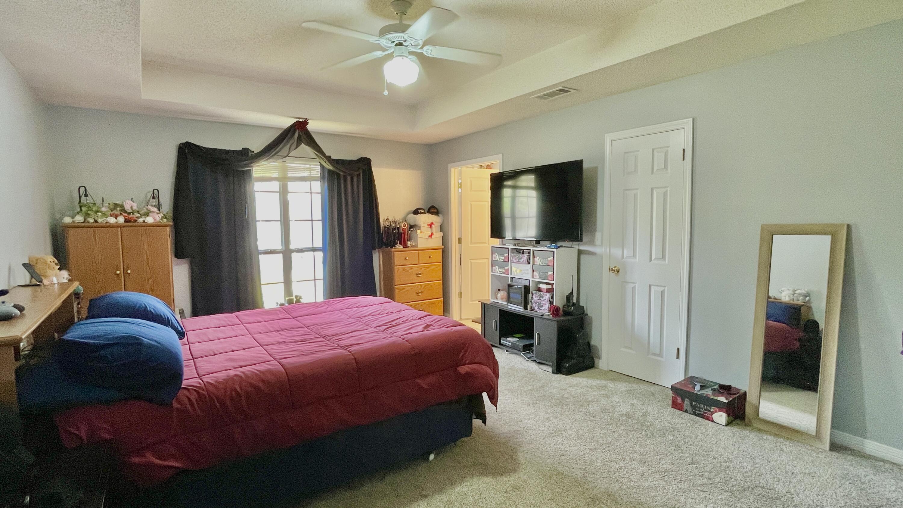4467 Kingslynn Road Niceville, FL 32578 - Photo 8 of 28 a bedroom with a bed and a flat tv screen on dresser