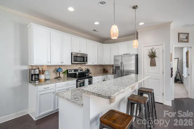 a kitchen with kitchen island granite countertop stainless steel appliances a stove sink microwave and cabinets