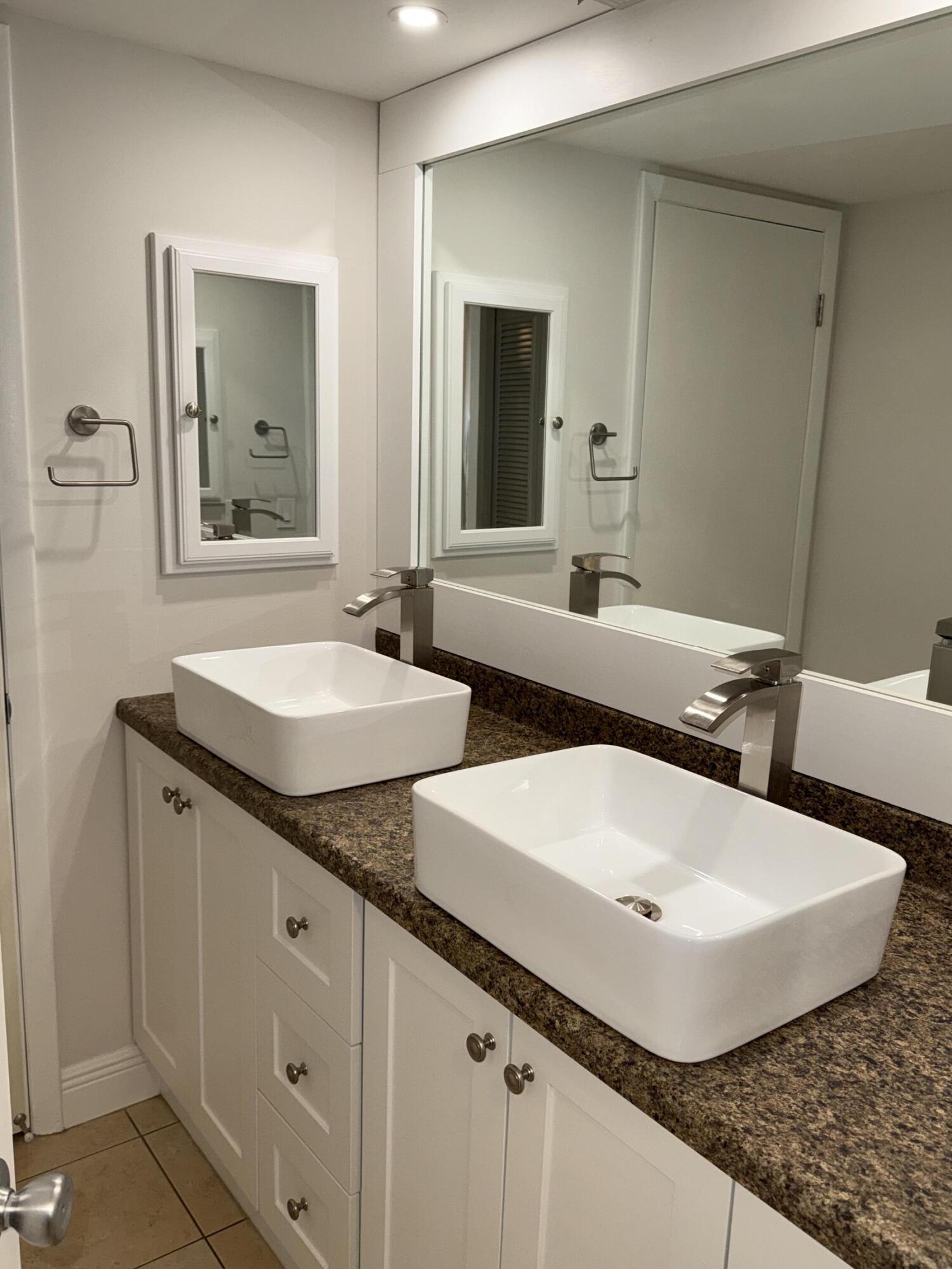 800 Northwest Fork Road, Unit 71 Stuart, FL 34994 - Photo 12 of 16 a bathroom with a double vanity sink and mirror