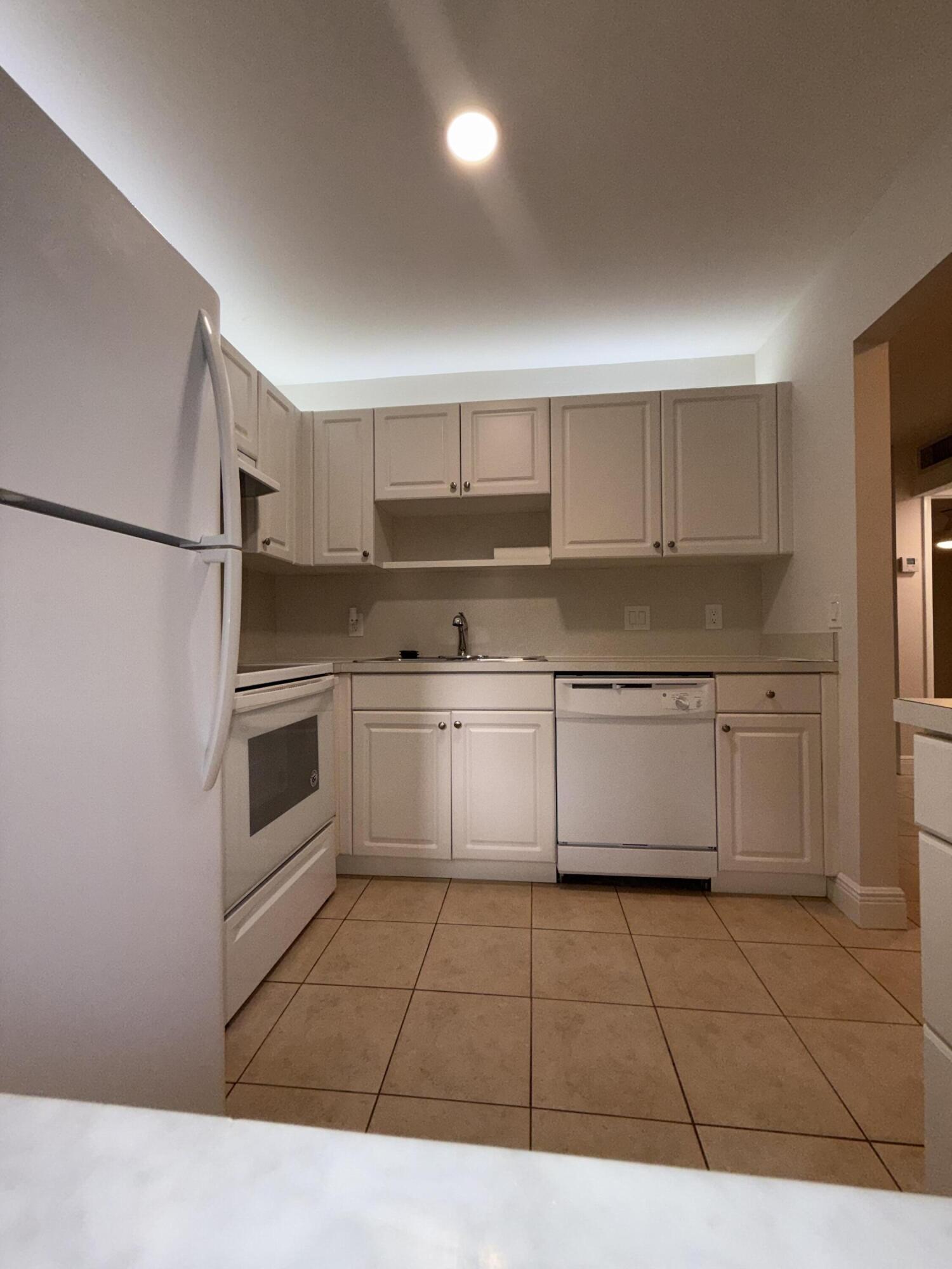 800 Northwest Fork Road, Unit 71 Stuart, FL 34994 - Photo 16 of 16 a kitchen with a stove a sink and a refrigerator